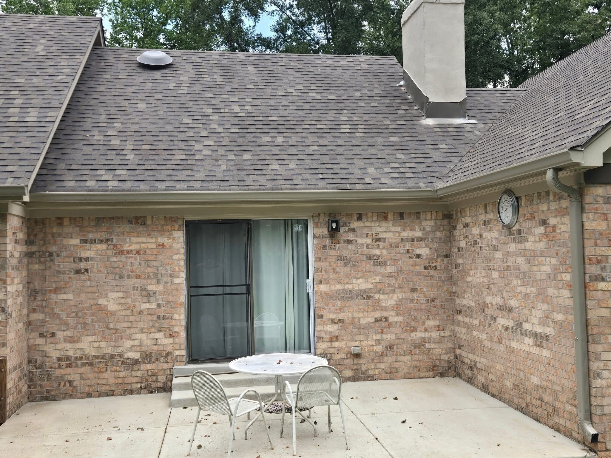 Rear brick patio elevation with a new shingle roof overhead