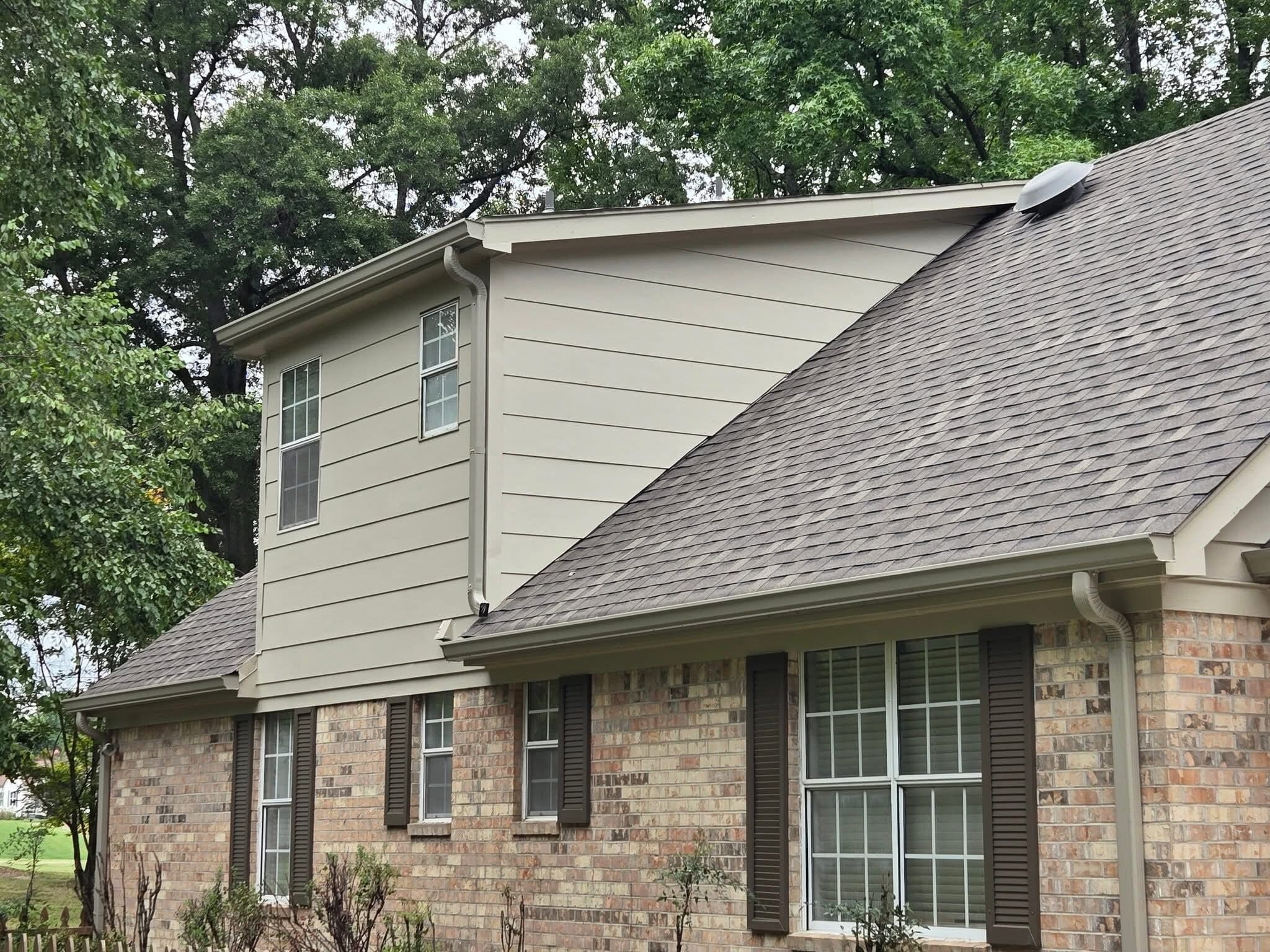 Two-story brick and siding home seen from the side yard