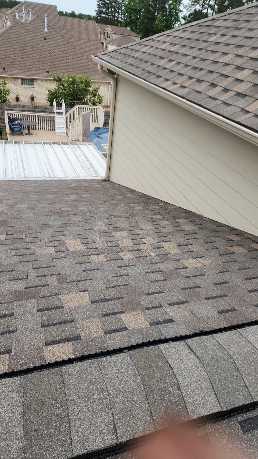 New shingle roof ridge with a backyard swimming pool visible below