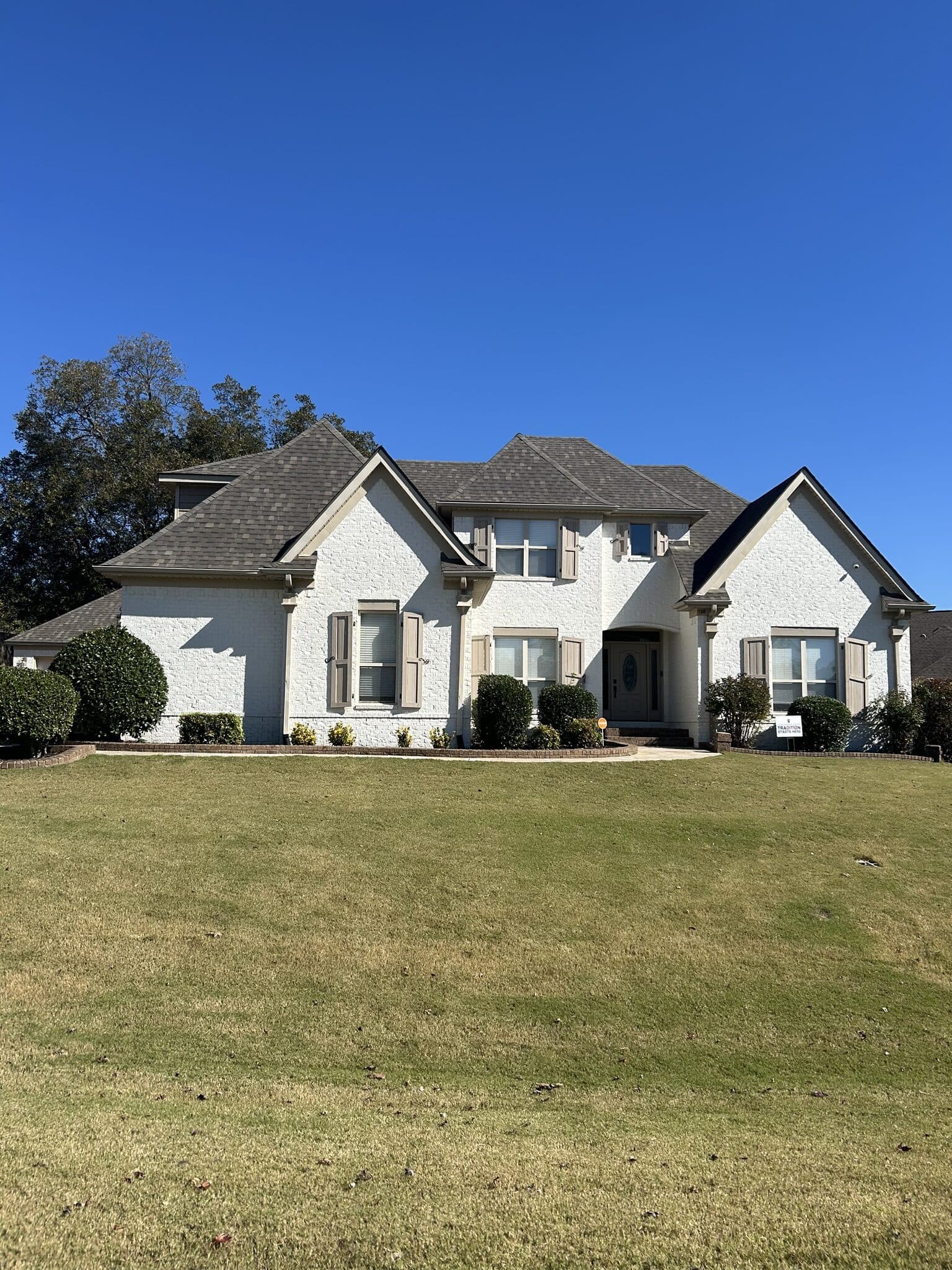 Home with a newly completed roof seen across the front lawn