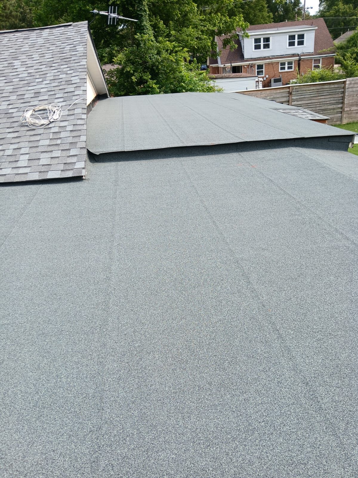 Gray granulated low-slope roofing on a residential addition