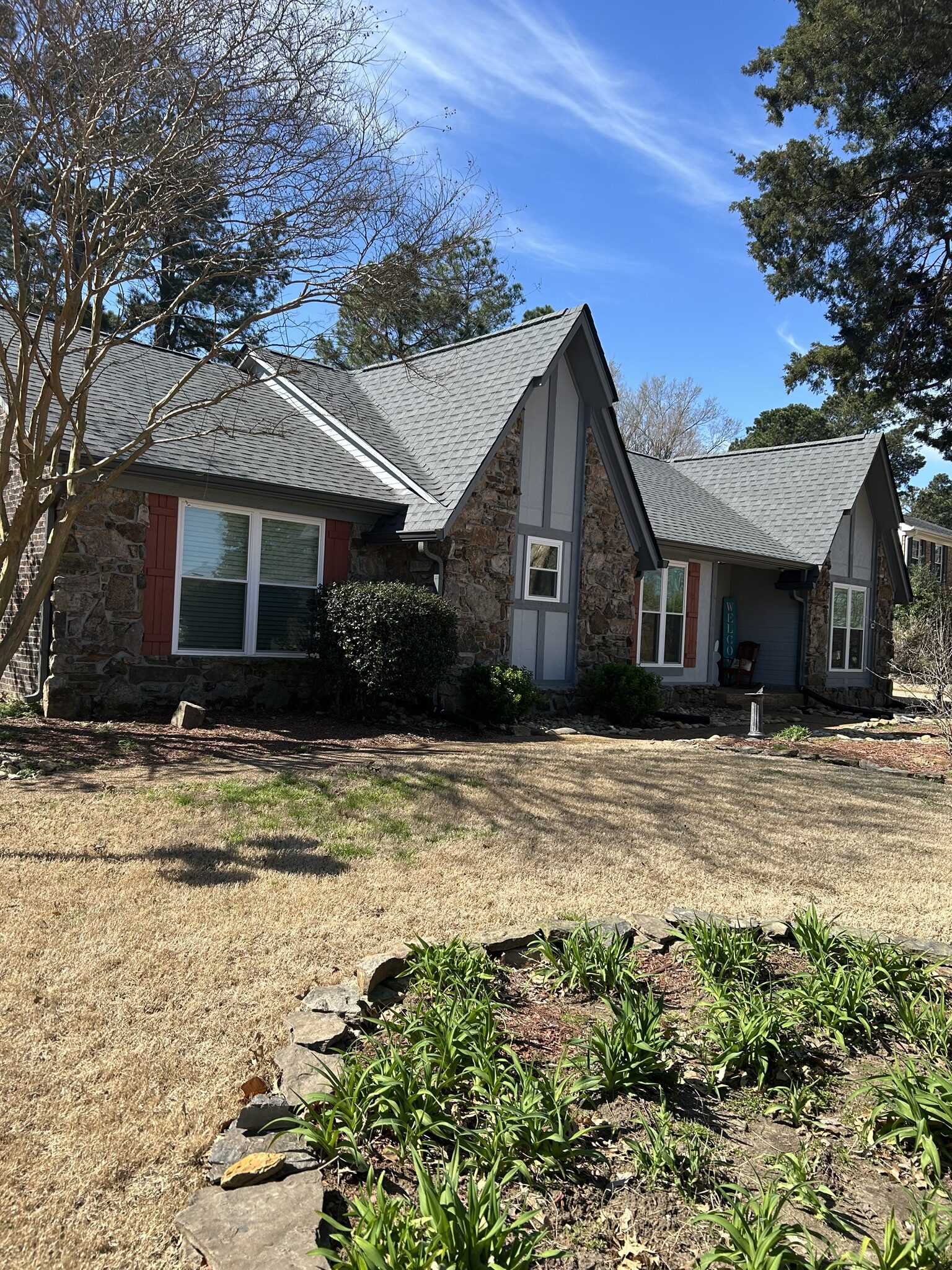 Stone and brick A-frame home seen from the front yard
